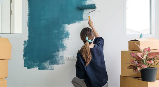 moça pintando parede de azul
