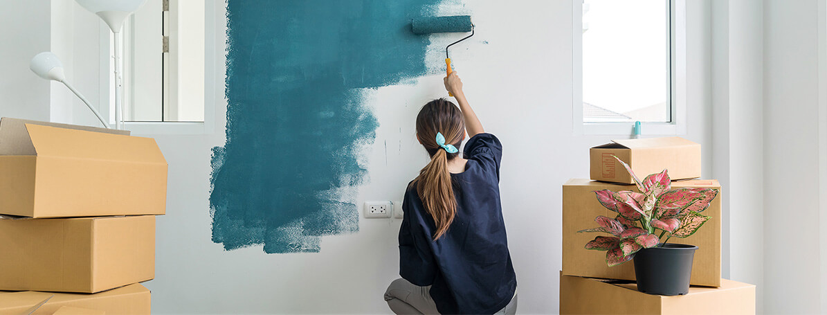 moça pintando parede de azul