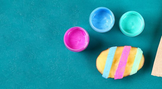 potes de tinta e pincéis sujos com tinta sobre um papel azul