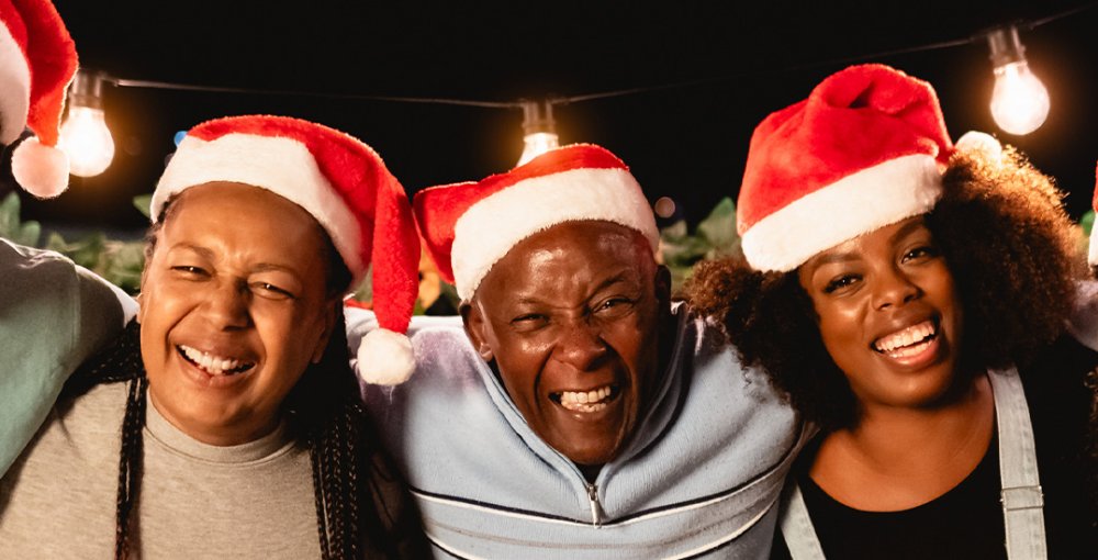 imagem de pessoas felizes com gorros de natal, representando o espírito cooperativo das festas natalinas