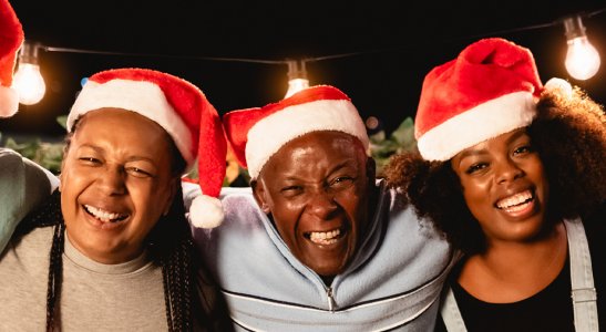 imagem de pessoas felizes com gorros de natal, representando o espírito cooperativo das festas natalinas